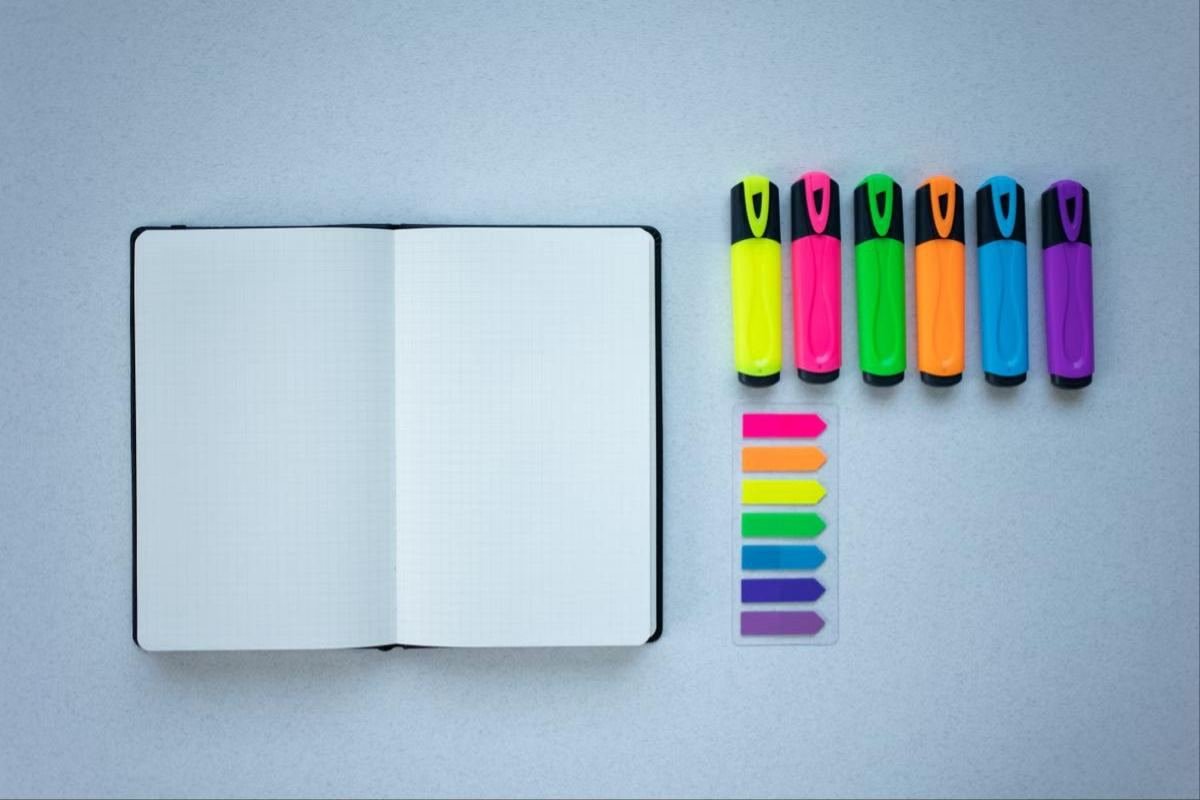Flat lay osnovci 1 Otvorena sveska sa markerima i stikerima u boji